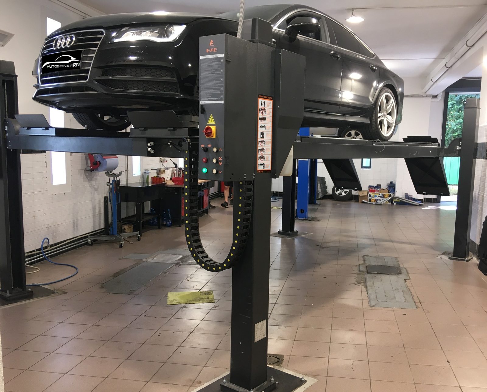 Čierne Audi zdvihnuté na zdviháku s ovládacím stĺpom